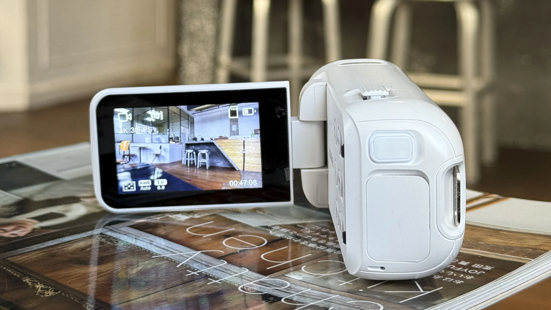 Yashica Journey 4K camcorder in white, rested on a surface with screen flipped out