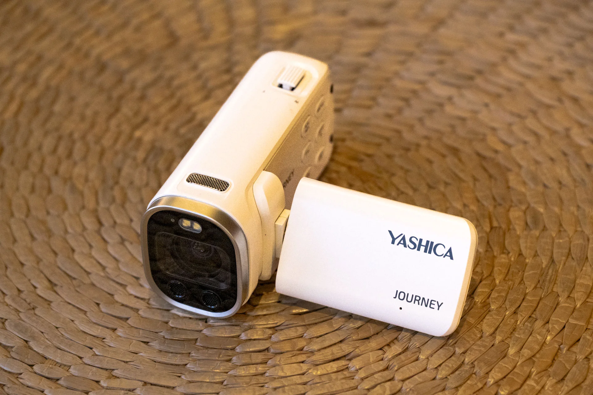 Yashica Journey 4K camcorder in white, rested on a surface with screen flipped out