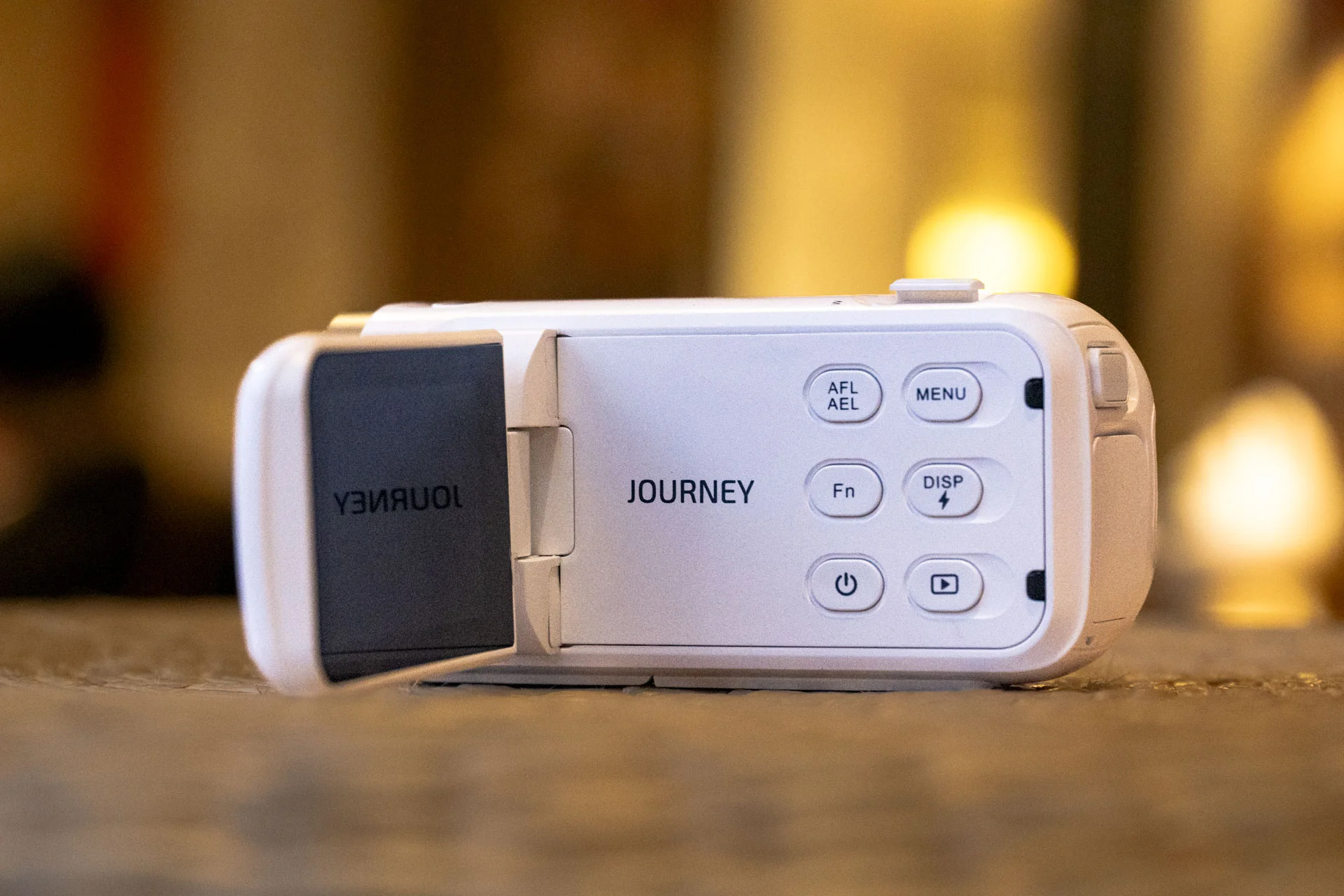 Yashica Journey 4K camcorder in white, rested on a surface with screen flipped out